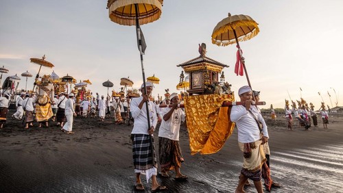 CANGGU, BALI, INDONESIA - MARCH 19:  Balinese Hindus woman in a state of trance, screams during Melasti Ritual prior to Nyepi Day on March 19, 2023 at Batubolong Beach, in Canggu Bali, Indonesia. After three years of performing purification ceremony ahead of Nyepi Day on a small scale due to the COVID-19 pandemic Balinese Hindus dressed in predominantly white attire carried sacred effigies of gods and goddesses and ritual paraphernalia from their village temples to the beach to perform a purification ceremony called the Melasti ritual. Balinese Hindus believe the Melasti ritual is a must perform ahead of Nyepi Day, The Day of Silence, to cleanse the soul and nature, recharge the supernatural power of the temples sacred objects and cleanse the temple paraphernalia. The Nyepi Day is a national holiday in Indonesia and is a day for self-reflection and abstaining from distractions such as entertainment. (Photo by Agung Parameswara/Getty Images)