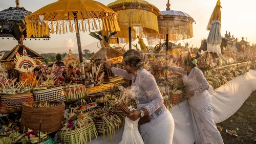 CANGGU, BALI, INDONESIA - MARCH 19:  Balinese Hindus woman in a state of trance, screams during Melasti Ritual prior to Nyepi Day on March 19, 2023 at Batubolong Beach, in Canggu Bali, Indonesia. After three years of performing purification ceremony ahead of Nyepi Day on a small scale due to the COVID-19 pandemic Balinese Hindus dressed in predominantly white attire carried sacred effigies of gods and goddesses and ritual paraphernalia from their village temples to the beach to perform a purification ceremony called the Melasti ritual. Balinese Hindus believe the Melasti ritual is a must perform ahead of Nyepi Day, The Day of Silence, to cleanse the soul and nature, recharge the supernatural power of the temples sacred objects and cleanse the temple paraphernalia. The Nyepi Day is a national holiday in Indonesia and is a day for self-reflection and abstaining from distractions such as entertainment. (Photo by Agung Parameswara/Getty Images)