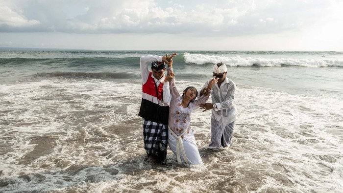 Umat Hindu Bali Menyucikan Diri dengan Upacara Melasti CANGGU, BALI, INDONESIA - MARCH 19: Balinese Hindus woman in a state of trance, screams during Melasti Ritual prior to Nyepi Day on March 19, 2023 at Batubolong Beach, in Canggu Bali, Indonesia. After three years of performing purification ceremony ahead of Nyepi Day on a small scale due to the COVID-19 pandemic Balinese Hindus dressed in predominantly white attire carried sacred effigies of gods and goddesses and ritual paraphernalia from their village temples to the beach to perform a purification ceremony called the Melasti ritual. Balinese Hindus believe the Melasti ritual is a must perform ahead of Nyepi Day, The Day of Silence, to cleanse the soul and nature, recharge the supernatural power of the temples sacred objects and cleanse the temple paraphernalia. The Nyepi Day is a national holiday in Indonesia and is a day for self-reflection and abstaining from distractions such as entertainment. (Photo by Agung Parameswara/Getty Images)