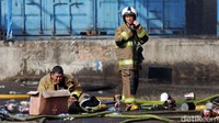 Beberapa petugas Damkar beristirahat usai berhasil memadamkan kebakaran.