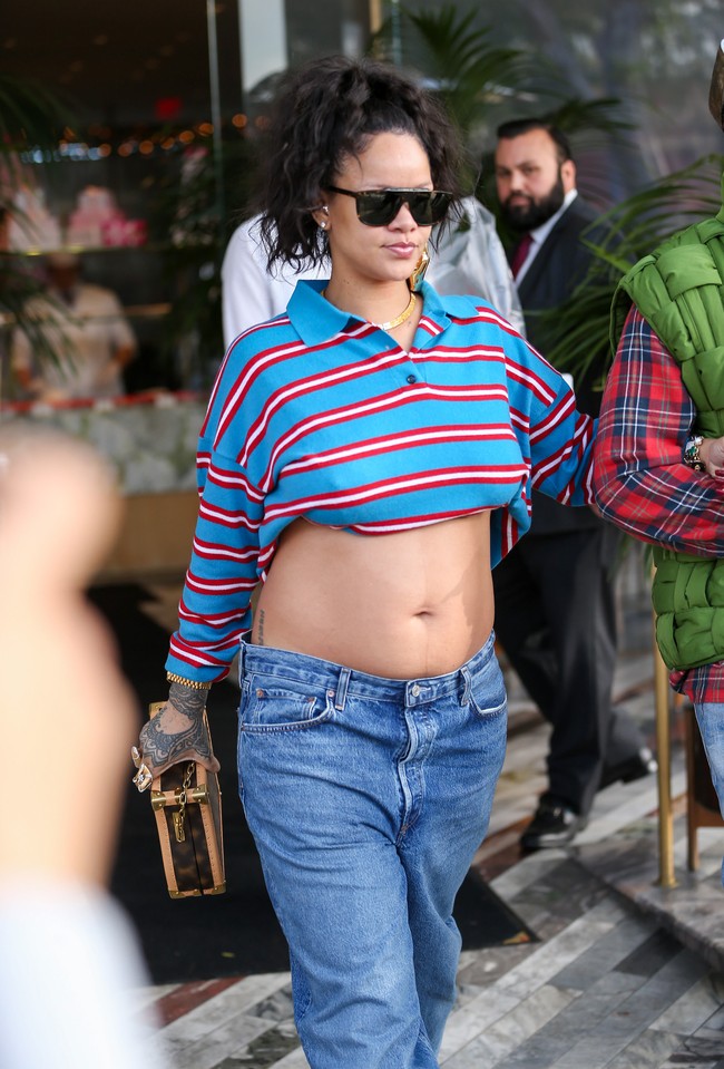 Muncul dengan street-style look yang stylish, Rihanna mengandalkan kombinasi crop top lengan panjang dan baggy jeans. Adapun atasannya merupakan polo shirt keluaran Loewe yang digulung sehingga memungkinkan pelantun Umbrella itu untuk memamerkan perut hamilnya.  (Foto: thecelebrityfinder/Bauer-Griffin/GC Images)