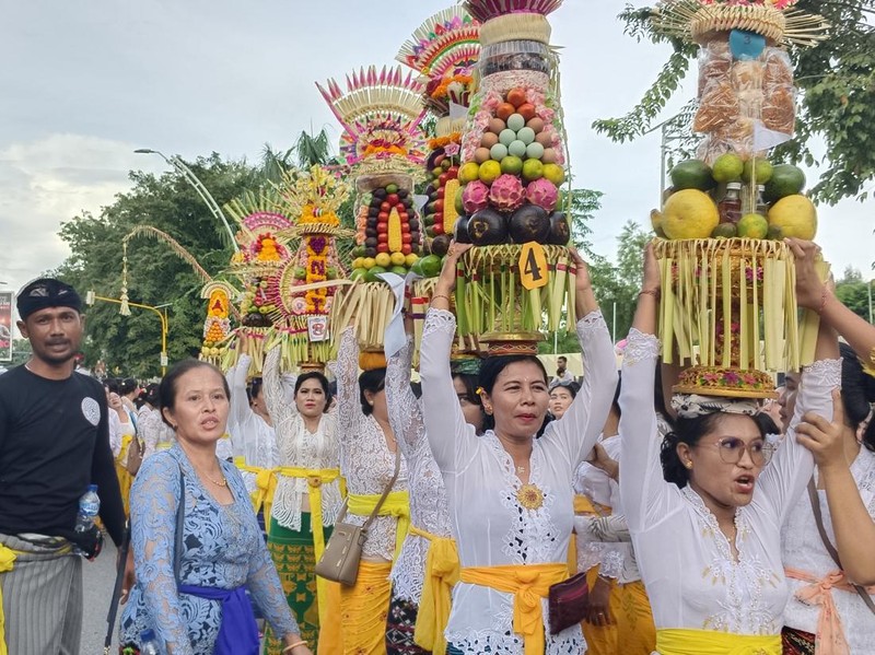 Iring-iringan tradisi mapeed yang dilakukan para perempuan yang membawa sesajen di atas kepala. Tradisi ini sebagai salah satu rangkaian kegiatan upacara yadnya. (Yufen Ernesto/detikBali)