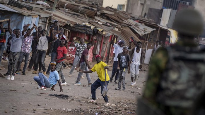 Kenya Chaos, Massa Demo Bentrok dengan Polisi A protester throws a rock at police as they demonstrate in the Kibera slum of Nairobi, Kenya Monday, March 20, 2023. Hundreds of opposition supporters took to the streets of the Kenyan capital over the result of the last election and the rising cost of living, in protests organized by the opposition demanding that the president resigns from office. (AP Photo/Ben Curtis)