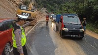 Jalan lintas Riau-Sumbar yang terputus akibat longsor sudah mulai bisa dilalui. Petugas gabungan bahu-membahu membersihkan material yang menutupi jalan.(Dok. BPBD dan Polda Riau)