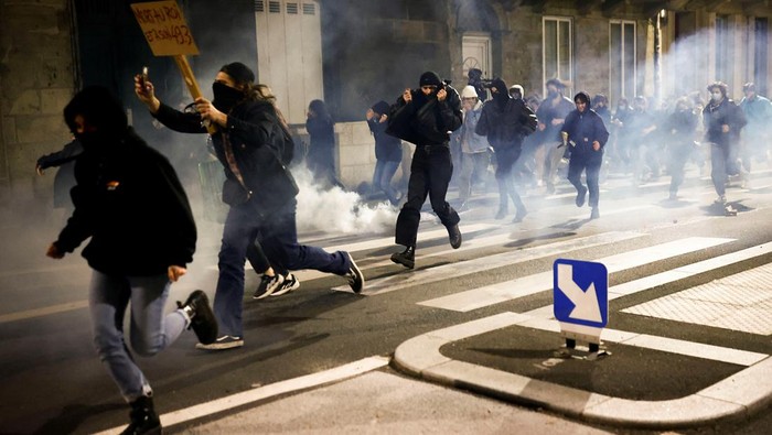 Protesters run amid clashes as they attend a demonstration on the day the National Assembly debates and votes on two motions of no-confidence against the French government, tabled by centrist group Liot and far-right Rassemblement National party, for its use of article 49.3, a special clause in the French Constitution, to push the pensions reform bill through the National Assembly without a vote by lawmakers, in Bordeaux, France, March 20, 2023. REUTERS/Stephane Mahe