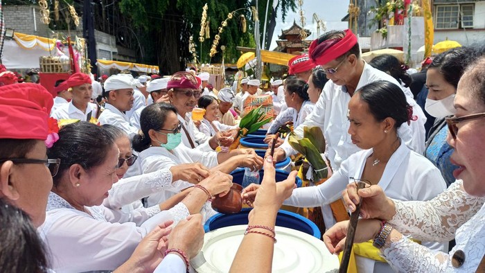 Proses pembagian tirta dan nasi tawur usai upacara Tawur Kesanga jelang Nyepi Tahun Saka 1945 di catus pata atau perempatan agung Desa Adat Kota Tabanan, Selasa (21/3/2023).