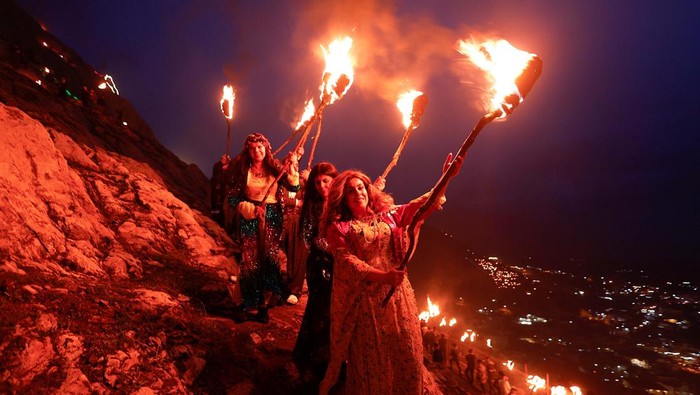 Warga Kurdi Irak Rayakan Nowruz, Festival Persia Kuno A man carries a fire torch while celebrating Nowruz Day, a festival marking the first day of spring and Persian New Year, in the town of Akra near Duhok, in Kurdistan, Iraq March 20, 2023. REUTERS/Alaa Al-Marjani
