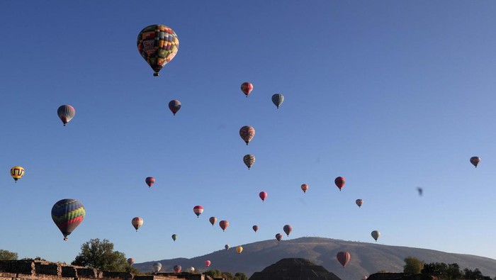 Warga Meksiko Menikmati Hangatnya Matahari Musim Semi Hot air balloons float above the Pyramid of the Moon on the day of the spring equinox in the pre-hispanic city of Teotihuacan, on the outskirts of Mexico City, Mexico, March 20, 2023. REUTERS/Henry Romero