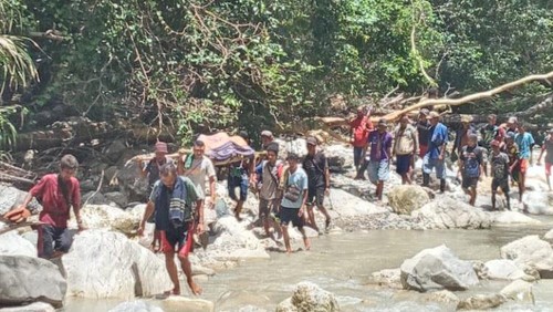 Warga menggotong jenazah korban terseret banjir Sungai Oatiba di Desa Fatusuki, Kecamatan Amfoang Selatan, Kabupaten Kupang, NTT, Senin (20/3/2/2023).