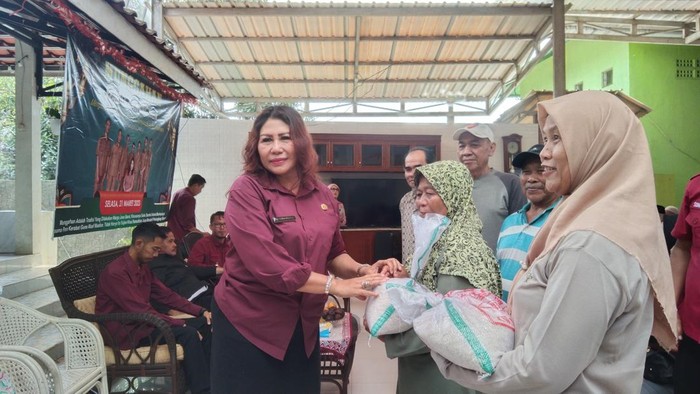 Yosa Novita (kiri) memberikan beras bagi warganya.