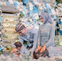 Dalam unggahan yang dibagikan terlihat acara tedak sinten baby Moana digelar dengan mewah didominasi warna biru. Dekorasinya tampak dipenuhi bunga-bunga yang juga berwarna biru, senada dengan pakaian yang dikenakan Ricis, Ryan, dan baby Moana. Foto: Instagram/@windrafotografi