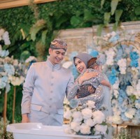 Teuku Ryan dan Ria Ricis terlihat kompak mengenakan busana adat Jawa berwarna biru keabuan, begitu pula dengan baby Moana. Ricis mengenakan kebaya yang dipadukan dengan kerudung berwarna senada, sementara Ryan tampil gagah dengan beskap di kepalanya. Foto: Instagram/@windrafotografi