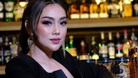 Sesekali Celine Evangelista juga mengunjungi bar untuk bersantai. Mengenakan pakaian hitam yang elegan ia tampak duduk di hadapan rak minuman beralkohol di sana. Foto: Instagram/celine_evangelista