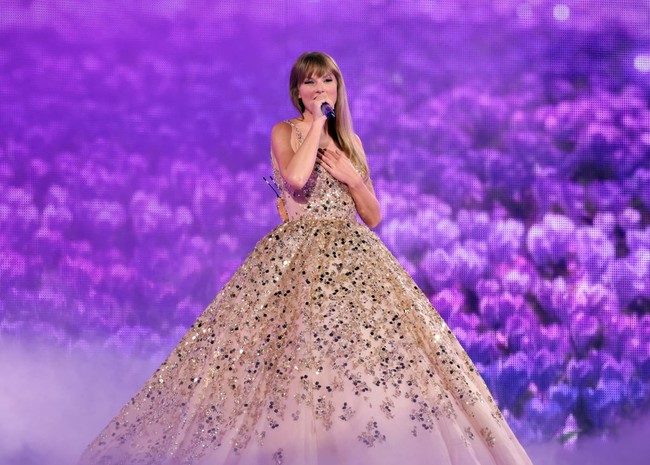 Taylor Swift tampil bak pengantin atau putri kerajaan saat menyanyikan lagu Enchanted dalam konsernya The Eras Tour. Gaun dengan detail emas yang megah ini merupakan karya dari Nicole + Felicia. Foto: Dok. Getty Images