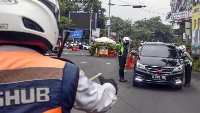 Libur Hari Nyepi, Jalur Puncak Terapkan Ganjil Genap Petugas Sat Lantas Polres Bogor dan petugas Dishub Kabupaten Bogor mengarahkan kendaraan wisatawan saat penyekatan kendaraan nomor polisi ganjil genap di jalur wisata Puncak, Gadog, Kabupaten Bogor, Jawa Barat, Rabu (22/3/2023). Kepolisian menerapkan kebijakan ganjil genap Jalur Puncak mulai dari tanggal 21 hingga 23 Maret 2023, kebijakan tersebut diambil guna mengantisipasi kepadatan arus kendaraan pada saat libur Hari Raya Nyepi dan libur cuti bersama awal Ramadhan. ANTARA FOTO/Yulius Satria Wijaya/hp.