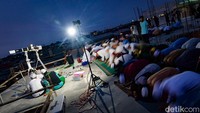 Sejumlah jemaah menunaikan salat magrib di atap masjid.