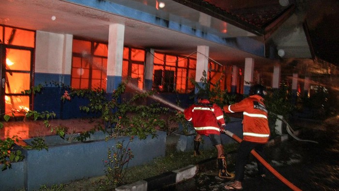 Sejumlah petugas dan relawan pemadam kebakaran berupaya memadamkan api yang membakar gedung Lembaga Penelitian dan Pengabdian Kepada Masyarakat (LPPM) Universitas Palangka Raya (UPR), Palangka Raya, Kalimantan Tengah, Rabu (22/3/2023) dini hari. Petugas dan para relawan pemadam kebakaran akhirnya berhasil memadamkan api yang menghanguskan seluruh isi ruangan gedung itu selama satu setengah jam, sementara penyebab kebarakan masih dalam penyelidikan. ANTARA FOTO/Makna Zaezar/hp.