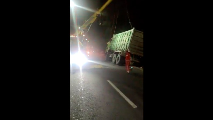 Truk terguling di Tol Jorr simpang Meruya (screenshot Twitter @TMCPoldaMetro)