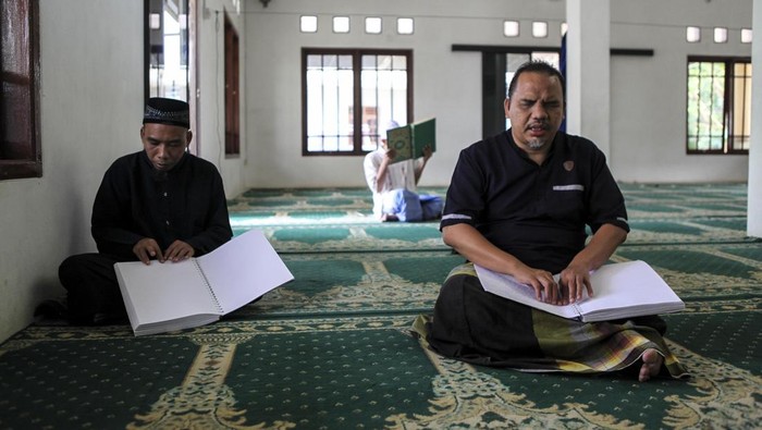 Khusyuknya Para Tunanetra Mengaji di Bulan Suci BANTEN, INDONESIA - MARCH 23: Visually impaired men read a Braille Quran at a mosque in South Tangerang, Banten, Indonesia, on March 23, 2023. Braille Quran is the translation of Quran verses to Braille symbols as it has been used by blind and visually impaired Muslims to recite the Quran. (Photo by Agoes Rudianto/Anadolu Agency via Getty Images)