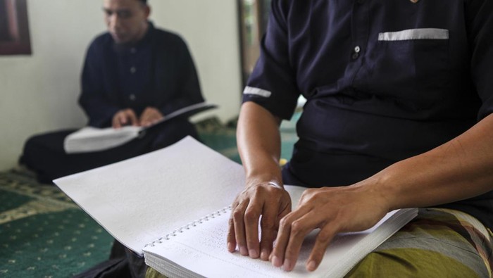 BANTEN, INDONESIA - MARCH 23: Visually impaired men read a Braille Quran at a mosque in South Tangerang, Banten, Indonesia, on March 23, 2023. Braille Quran is the translation of Quran verses to Braille symbols as it has been used by blind and visually impaired Muslims to recite the Quran. (Photo by Agoes Rudianto/Anadolu Agency via Getty Images)