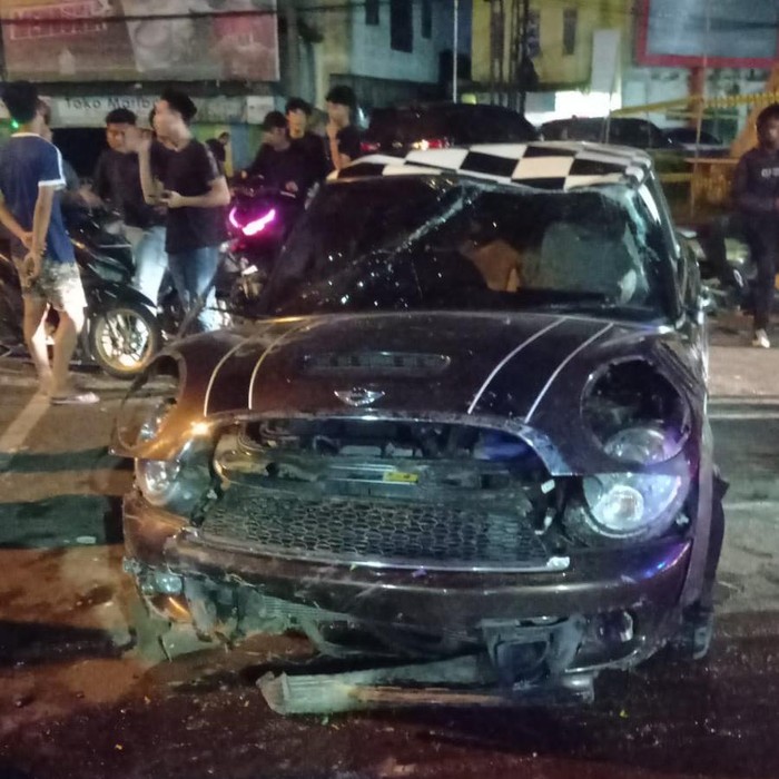 Mobil Minu Cooper terbalik usai menabrak pembatas jalan di Medan.