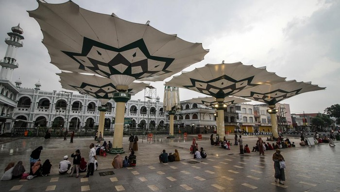 Sejumlah warga mengunjungi wisata payung Madinah di depan Masjid Agung Al-Anwar di kawasan Alun-alun Kota Pasuruan, Jawa Timur, Kamis (23/3/2023). Payung Madinah menjadi tempat favorit bagi warga untuk beraktivitas sambil ngabuburit atau menunggu waktu berbuka puasa. ANTARA FOTO/Umarul Faruq/YU