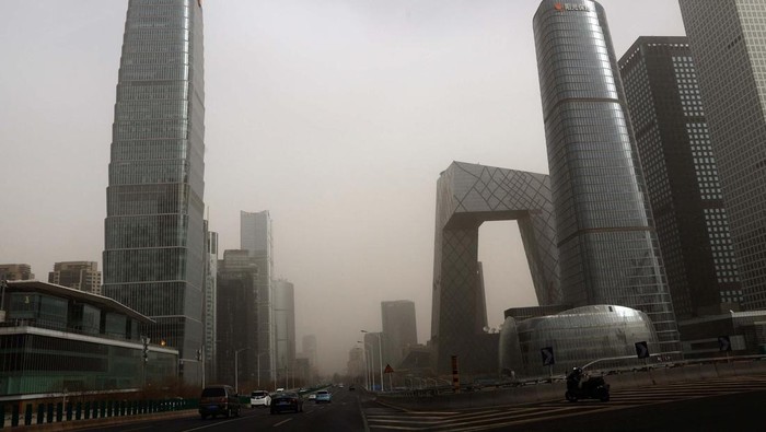 People walk amid a sandstorm at a park in Beijing, China March 22, 2023. REUTERS/Tingshu Wang