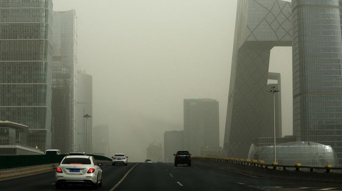 People walk amid a sandstorm at a park in Beijing, China March 22, 2023. REUTERS/Tingshu Wang