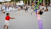 Sejumlah pengunjung bermain di Pantai Lagoon Ancol, Jakarta, Kamis (23/3/2023). (ANTARA FOTO/M Risyal Hidayat)  