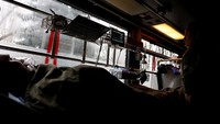 Seorang tentara terbaring dalam perawatan di bus medis.  