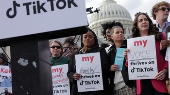 Para pendemo membawa poster yang menyuarakan manfaat TikTok bagi mereka. Foto: Getty Images