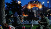 Warga berbuka puasa dengan latar belakang Masjid Hagia Sophia.