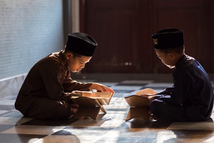 Muslim boy reads the quran in mosque islamic concept