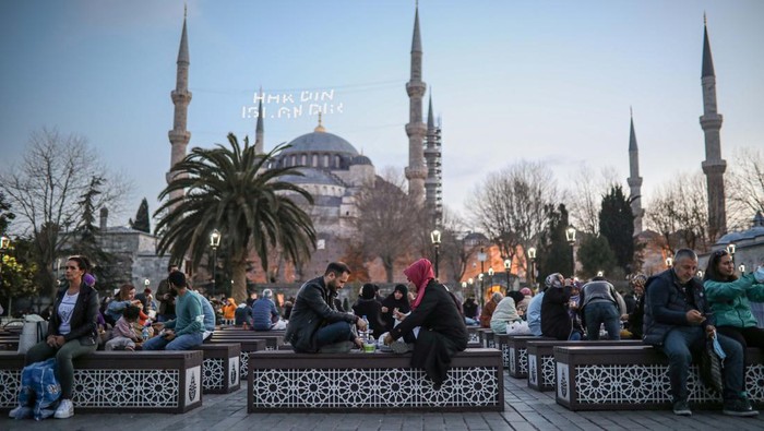 Masjid Biru dan Hagia Sophia Jadi Spot Buka Puasa Favorit di Turki ISTANBUL, TURKIYE - APRIL 02: Tourists and citizens have fast-breaking (iftar) dinner in the first day of Muslim's holy month Ramadan at Sultanahmet Square in Istanbul, Turkiye on April 02, 2022. (Photo by Salih Zeki Fazlioglu/Anadolu Agency via Getty Images)