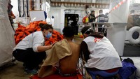 Petugas medis merawat migran yang kelelahan di kapal penyelamat Geo Barents.