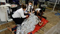 Salah satu migran yang kedinginan dan kelelahan ditutup kain aluminium foil.