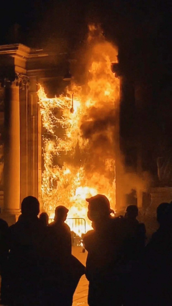 People look at the Bordeaux town hall in flames during a demonstration as part of the ninth day of nationwide strikes and protests against the French government's pension reform, in Bordeaux, France, March 23, 2023, in this screengrab obtained from a social media video. Twitter Bookee0/via REUTERS  THIS IMAGE HAS BEEN SUPPLIED BY A THIRD PARTY. MANDATORY CREDIT. NO RESALES. NO ARCHIVES.