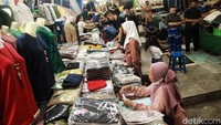 Jemaat beribadah di antara pengunjung yang melakukan aktivitas jual beli di pasar tersebut.