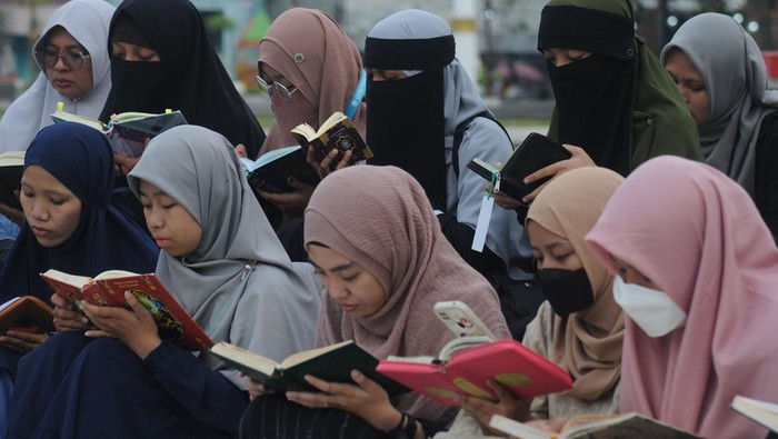 Sejumlah pemudi mengaji bersama saat ngabuburit di Alun-alun Klaten, Jawa Tengah, Kamis (23/3/2023). Kegiatan Klaten Mengaji di ruang publik yang diikut sebanyak 200 peserta pemuda Islam itu untuk mengisi waktu menjelang berbuka puasa serta mengajak masyarakat luas mengenal lebih dalam tentang Al Quran pada Bulan Suci Ramadhan. ANTARA FOTO/Aloysius Jarot Nugroho/YU