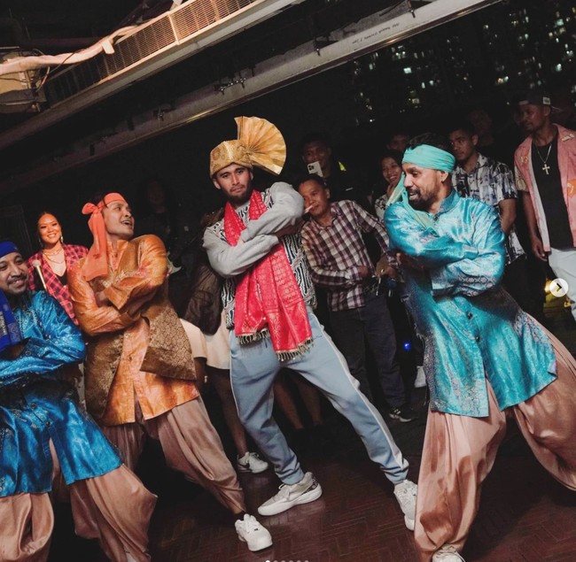 Tak hanya menari, Sabda juga tampak bergaya ala Shah Rukh Khan. Melalui keterangan di unggahan Instagramnya Sabda menulis menggunakan bahasa Inggris, “Sekarang aku tahu bagaimana rasanya menjadi Shah Rukh Khan dalam film Bollywood dan bernyanyi berduet dengan penyanyi jazz dan jowo favorit saya. grazie bella @wulanguritno.” Foto: Instagram/@sabdaahessa