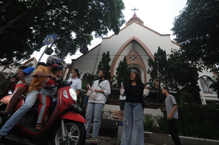 Anggota Orang Muda Katolik (OMK) Gereja Katolik Santo Paulus Miki membagikan takjil kepada pengendara motor di Salatiga, Jawa Tengah, Jumat (24/3/2023). Kegiatan berbagi takjil gratis sebanyak 200 bungkus per hari selama bulan suci Ramadhan 1444 H yang dilakukan oleh Umat Katolik setempat itu untuk menjaga kebersamaan dalam nilai-nilai toleransi antarumat beragama. ANTARA FOTO/Aloysius Jarot Nugroho/aww.
