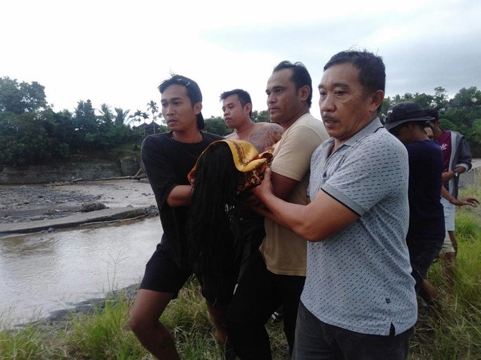 Warga mengevakuasi korban tenggelam di sungai dekat Bendung Tegalgintungan, Lingkungan Munduk Anyar, Kecamatan Mendoyo, Jembrana, Bali, Kamis (23/3)2023). (Foto: Istimewa)