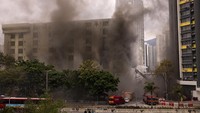 Asap mengepul dari gudang yang terbakar. AP Photo/Louise Delmotte