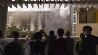 Kebakaran menjadi tontonan warga. Bahkan sebagian dari mereka tampak mengabadikan menggunakan handphone. AP Photo/Louise Delmotte