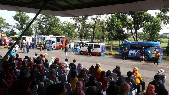 Warga antre menukarkan uang baru tahun emisi 2022  pada sejumlah mobil kas keliling di GOR Jayabaya, Kota Kediri, Jawa Timur, Sabtu (25/3/2023). Bank Indonesia kantor perwakilan Kediri bekerja sama dengan tujuh bank umum membuka layanan penukaran uang baru lebih awal dengan menyediakan uang kartal sejumlah Rp5,1 triliun pada 70 kantor cabang perbankan di 13 kota/kabupaten eks karesidenan Kediri-Madiun dan 13 kas keliling di pusat keramaian selama bulan Ramadhan. ANTARA FOTO/Prasetia Fauzani/rwa.