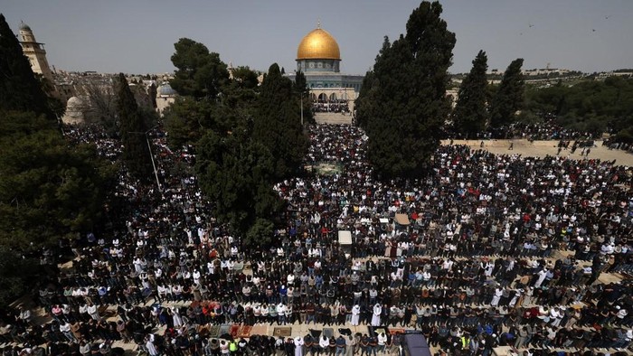 People perform the first Friday noon prayer of the Islamic fasting month of Ramadan, in front of the Dome of the Rock shrine at the Al-Aqsa mosque compound in Jerusalem, on March 24, 2023. (Photo by AHMAD GHARABLI / AFP)