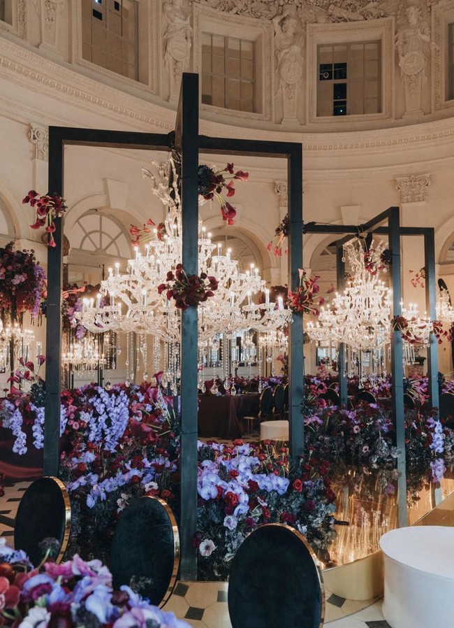 Lampu chandelier yang ditempatkan pada tiap set meja panjang menambah keindahan dekorasi yang penataannya cantik tanpa terkesan berlebihan. Foto: Instagram/@morden.co, @audreyparisphoto