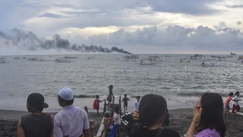 Sejumlah warga menyaksikan Kapal tanker MT Christian yang terbakar di perairan Pantai Ampenan, Mataram, NTB, Minggu (26/3/2023). Kapal tanker yang mengangkut BBM tersebut terbakar di tengah laut tidak jauh dari Terminal BBM Ampenan sekitar pukul 15.00 Wita dan mengakibatkan tiga anak buah kapal meninggal dunia dan sisanya  berhasil di evakuasi.ANTARA FOTO/Ahmad Subaidi/nz