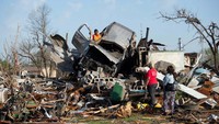 Sebuah mobil jungkir balik disapu tornado dan mendarat di atas puing-puing.