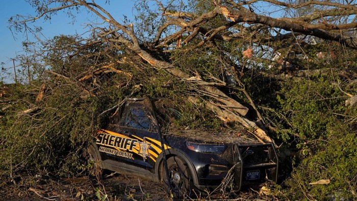 A law enforcement vehicle is seen underneath a fallen tree after thunderstorms spawning high straight-line winds and tornadoes ripped across the state in Rolling Fork, Mississippi, U.S., March 25, 2023. REUTERS/Cheney Orr